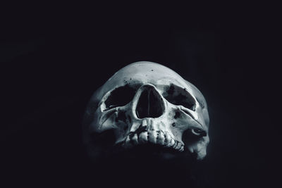 Close-up of human skull against black background