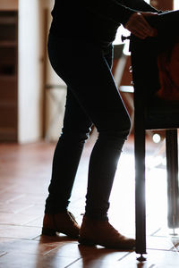 Low section of woman standing on floor at home