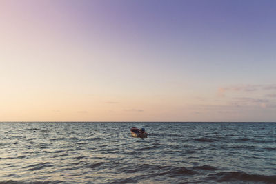 Tiny boat isolated on the sea on colorful sunset. concept of lonely.