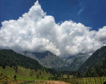 Scenic view of field and mountains against sky