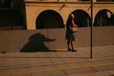 Rear view of women walking on tiled floor
