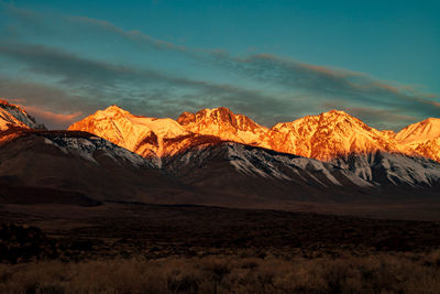 Scenic view of snowcapped mountains against sky during sunset