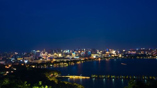 Illuminated cityscape against clear sky at dusk