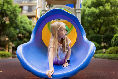 Girl lying on slide at park