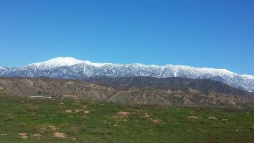 Scenic view of mountains against clear blue sky