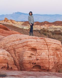 Full length of young man standing on rock formation