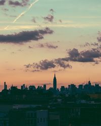 View of cityscape against cloudy sky