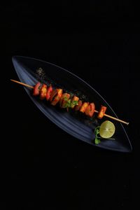 High angle view of cake on plate against black background