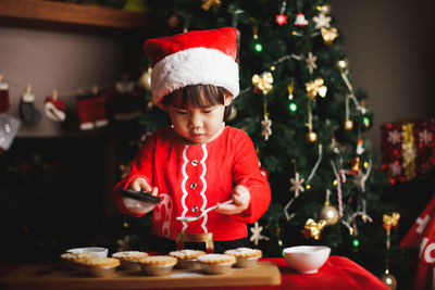 Girl preparing cookies on table during christmas