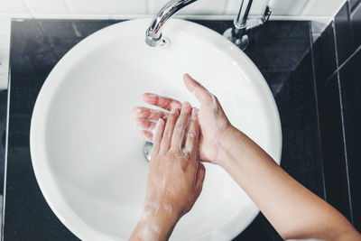 Midsection of woman in bathroom at home