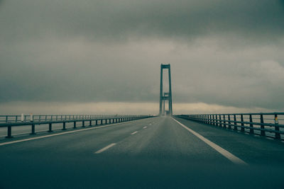 Empty road with bridge against sky