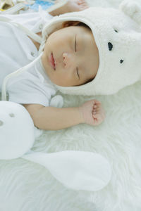 Cute baby boy sleeping on bed at home