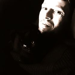 Close-up portrait of man with hand in black background