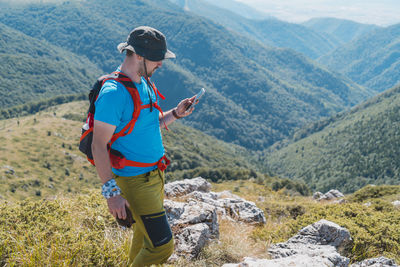 Full length of man using mobile phone on mountain