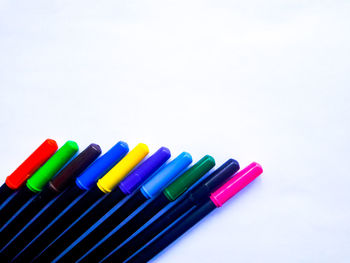 Close-up of colored pencils over white background