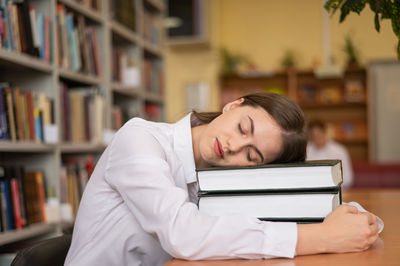 Side view of young woman using laptop at home