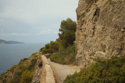 Scenic view of mountains by sea against sky