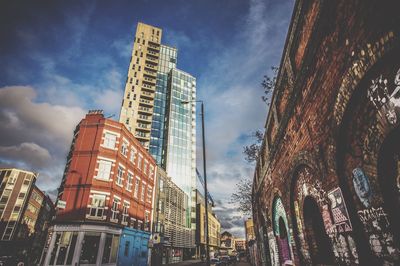 Low angle view of buildings against cloudy sky