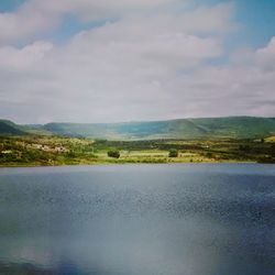 Scenic view of lake against cloudy sky