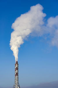 Smoke emitting from chimney against sky