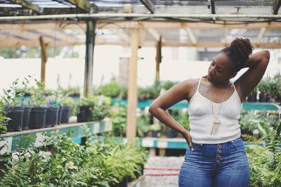 Woman standing by plants in store