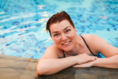 Portrait of a smiling young woman in swimming pool