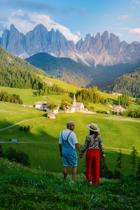 Rear view of men on field against mountains