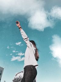 Low angle view of woman standing against sky