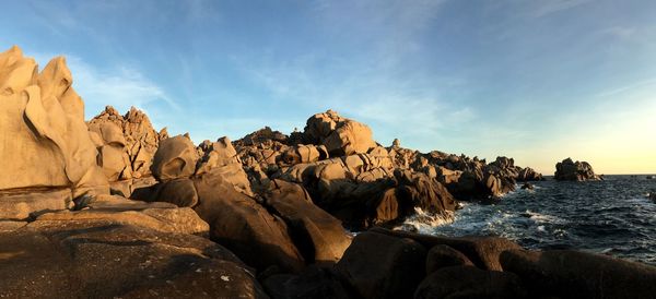 Panoramic view of rocks on beach against sky