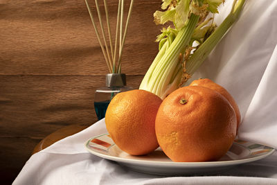 Close-up of orange fruits in vase on table