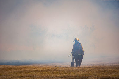 Man standing on field against sky