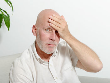 Portrait of man against white wall at home