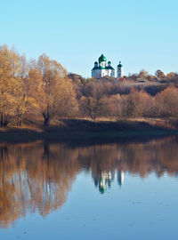 Building by lake against clear sky