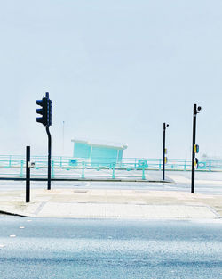 Empty road by street against clear sky