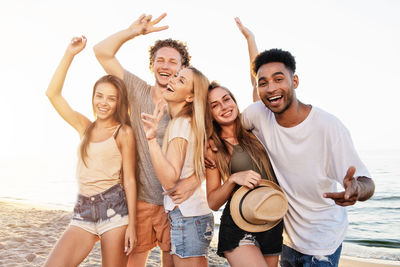 Portrait of friends standing at beach