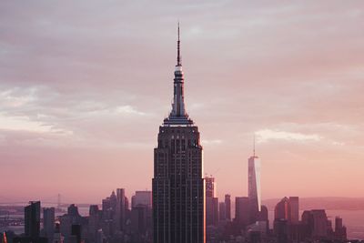 Skyscrapers in city against cloudy sky