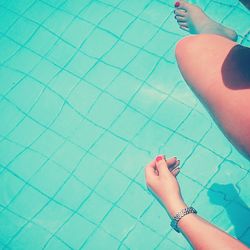 Low section of woman relaxing in swimming pool