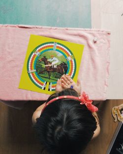 Directly above view of girl playing board game at home