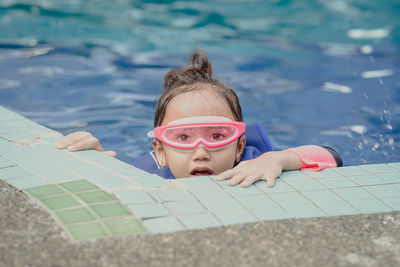 Portrait of young woman swimming in pool