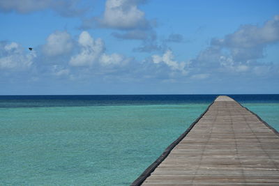 Pier over sea against blue sky