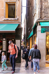 People walking on street against buildings in city