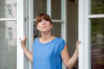 Young woman looking through window