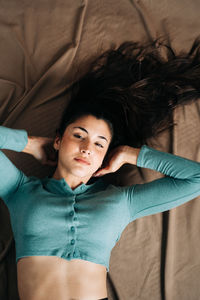 Portrait of young woman lying in bed