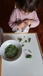 High angle view of woman holding food in bowl