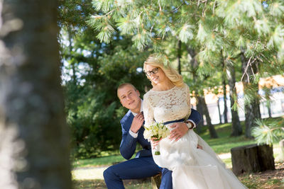 Portrait of bridal couple sitting at park