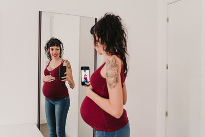 Woman standing against wall at home