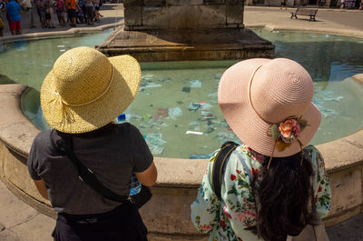 Rear view of man with woman sitting in water