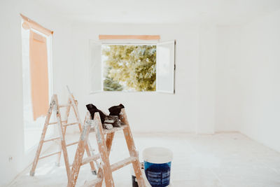 Ladders and painter tools on white room at construction site. painting walls. home improvement