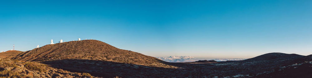 Scenic view of rocky mountains against clear blue sky