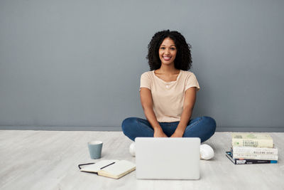 Portrait of young woman sitting on table